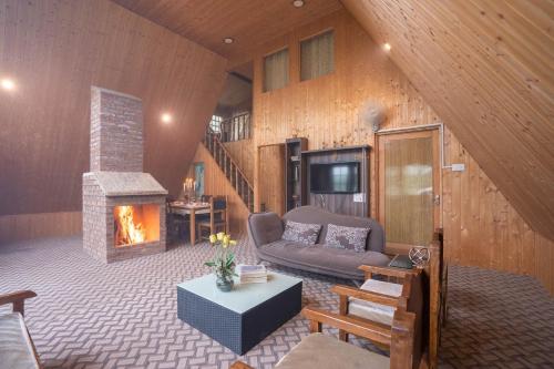 a living room with a couch and a fireplace at StayVista at Lavender Haze - 3BR Cottage in Pahalgām