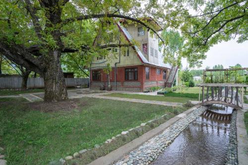 a house with a pond in front of a building at StayVista at Lavender Haze - 3BR Cottage in Pahalgām