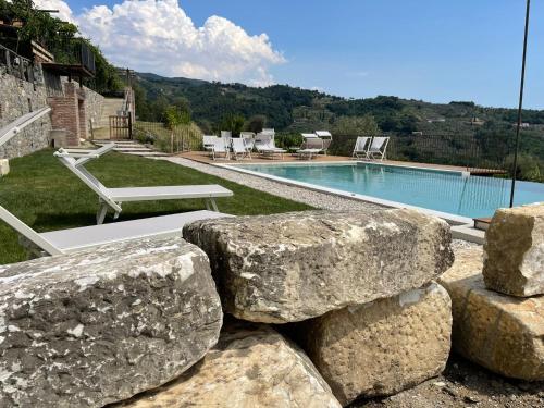 a resort with a swimming pool and some rocks at Agriturismo La Burlanda in Fosdinovo