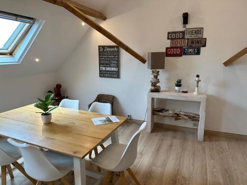 jadalnia z drewnianym stołem i krzesłami w obiekcie Magnifique loft 2-3 personnes tout confort w mieście Boulogne-sur-Mer