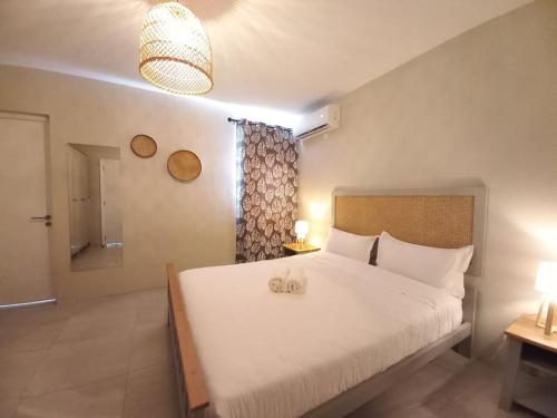 a bedroom with a large white bed and a window at Bois Mapou Self Catering Apartments Unit 201 in Rivière Noire