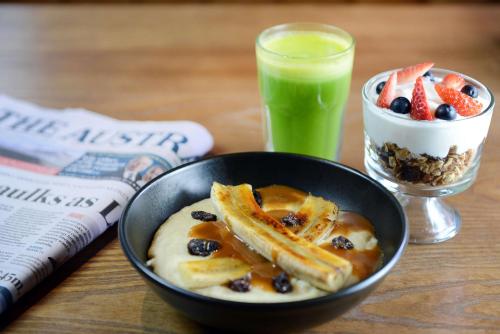 a bowl of food with fruit and a drink on a table at Rydges Armidale in Armidale