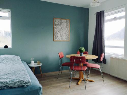 een kamer met een bed en een tafel en stoelen bij Gistiheimilið Bergistangi 1 in Norðurfjörður