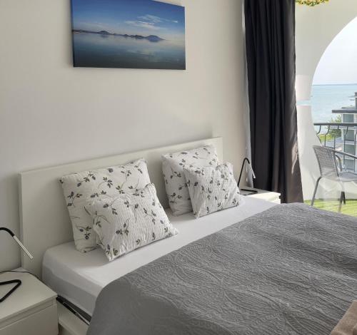 a bedroom with a bed with a view of the ocean at Vízparti Apartman in Siófok