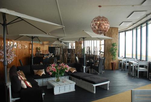 a living room with couches and tables and umbrellas at Ocean BreezeApartment: WakeUp 2 Sound of the Waves in Zandvoort