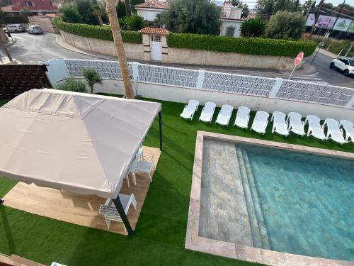 einen Blick über den Pool mit Zelt und Stühlen in der Unterkunft Vistalmar in San Juan de Alicante