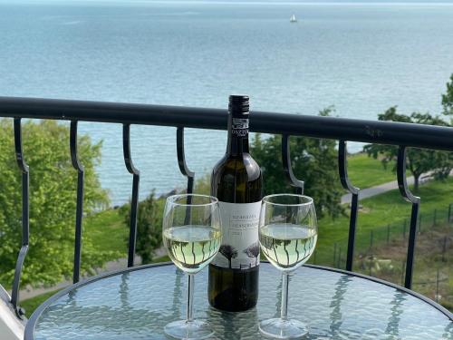 a bottle of wine and two glasses on a table at Vízparti Apartman in Siófok