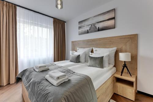 a bedroom with a large bed with towels on it at Downtown Apartments Seaside Baltea Park & Parking in Gdańsk