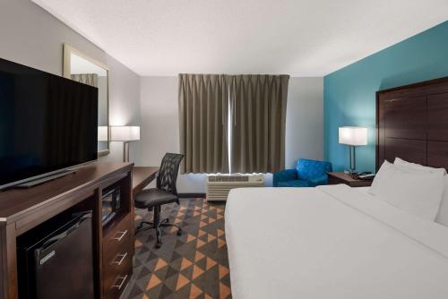 a hotel room with a bed and a flat screen tv at Clarion Pointe Indianapolis Northeast in Castleton