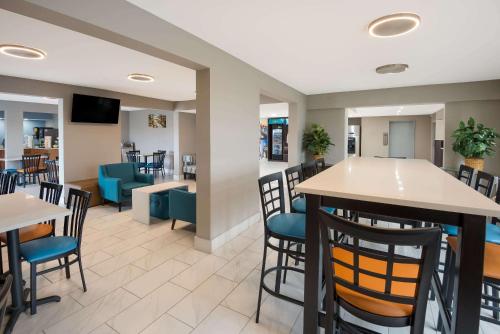 a bar in a restaurant with tables and chairs at Clarion Pointe Indianapolis Northeast in Castleton