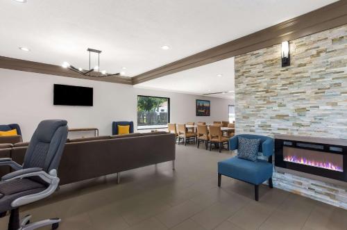 a waiting room with a fireplace and chairs at Quality Inn South Bend near Notre Dame in South Bend