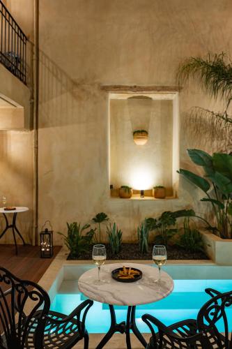 a patio with a table and two glasses of wine at Casa di Gaga Luxury Suites in Rethymno Town