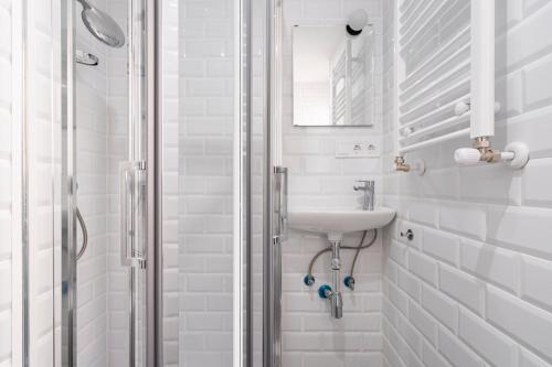 a white bathroom with a sink and a shower at Apartamento exclusivo en Tetuan con Parking opcional in Madrid