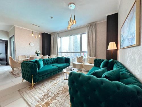 sala de estar con sofás verdes y comedor en Durrani Homes - Grand 5BR besides Burj khalifa and Fountain view en Dubái