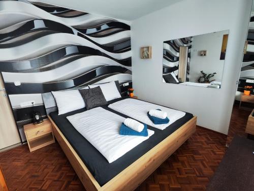 a bedroom with a large bed and a mirror at ALPINpelso in Sankt Michael im Lungau