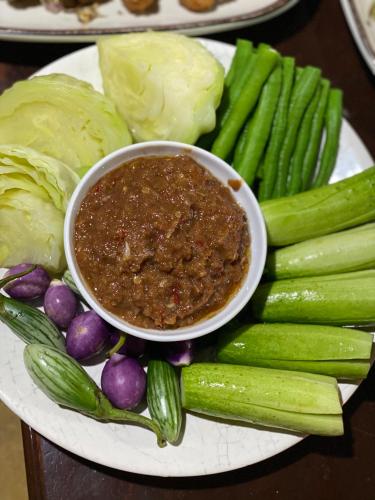 a plate of vegetables with a bowl of chili at นิทานคำกลอน 2 Nithankumkon 2 in Amphawa