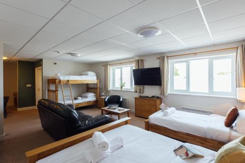 a room with two beds a couch and a tv at The Imperial Dragon Hotel in Saundersfoot
