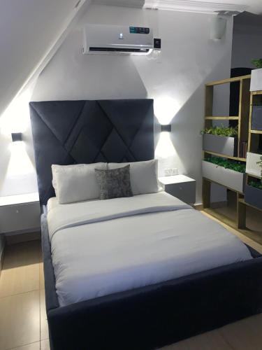 a bedroom with a large bed with a black headboard at Loft Studio Unit in Lekki phase 1 - 2 ACs, Kitchen, Closet & Ironing room, Netflix, WI-FI, Bath tub 1 in Lagos