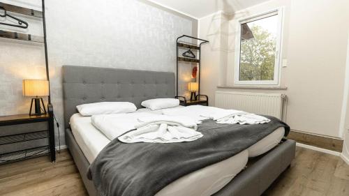 - une chambre avec un grand lit et une couverture noire dans l'établissement Apartment Harzduft zentrumnah GrillChill Garten, à Thale