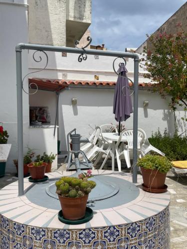 a patio with an umbrella and potted plants at Patio da Foz - Appartement très accueillant centre-ville in Figueira da Foz