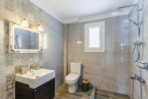ein Badezimmer mit Waschbecken und Toilette und einem Fenster in der Unterkunft Skopelos Home in Skopelos