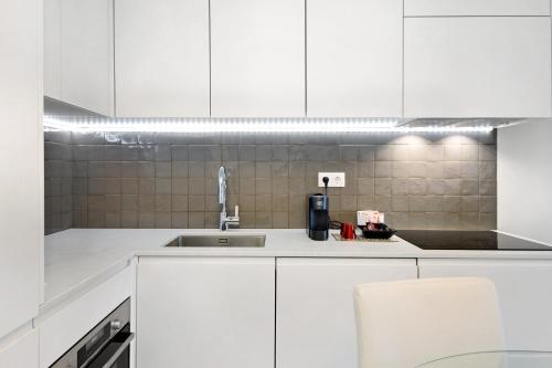 a kitchen with white cabinets and a sink at Uno del Mar 2 in Vila Nova de Gaia