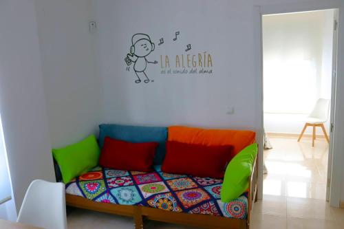 a room with a bed with colorful pillows and a sticker on the wall at Mi UNIVERSO in San Fernando
