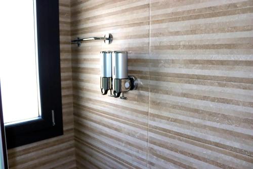 a shower stall with a soap dispenser on the wall at UNIVERSO in San Fernando