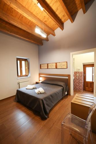 a bedroom with a bed in a room with wooden ceilings at Camere U Campanaru in Gratteri
