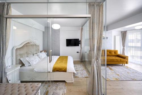 Un dormitorio con una cama y una pared de cristal. en Magic Studio in Infinity Beach Resort Pool & Parking, en Mamaia