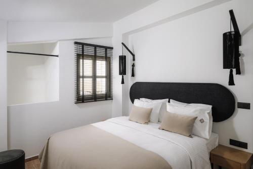 a white bedroom with a white bed with white pillows at Casa di Gaga Luxury Suites in Rethymno Town