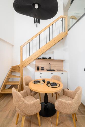 a dining room with a table and chairs and a staircase at Casa di Gaga Luxury Suites in Rethymno Town