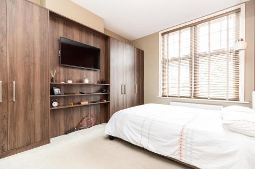 a bedroom with a bed and a flat screen tv at Alton Chambers in Parkstone