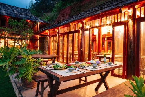 una mesa de madera con tazones de comida en el patio en Natalie's Villa & Resort, en Mộc Châu