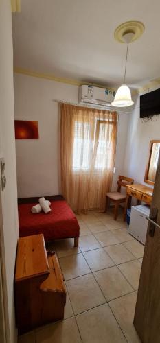 a bedroom with a bed and a table and a table at Atlas Pension in Karterados