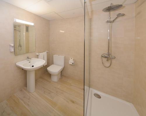a bathroom with a toilet and a sink and a shower at Sunside Central Park Apartamentos - Only Adults in San Antonio