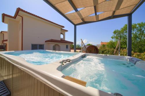 a jacuzzi tub sitting on top of a house at Holiday house SEA & SUN RESIDENCE in Rasopasno