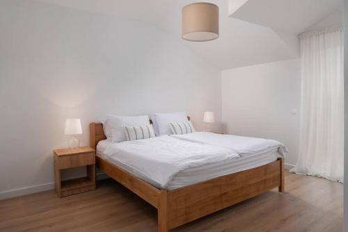 1 dormitorio con 1 cama grande con sábanas blancas en Spacious and fully equipped apartment near Zadar, en Smoković