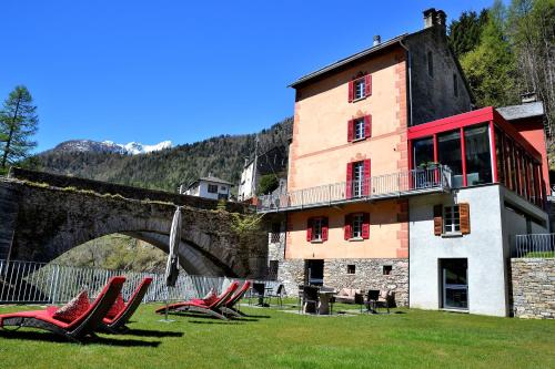 a group of red chairs in front of a building at Unique Hotel Fusio in Fusio