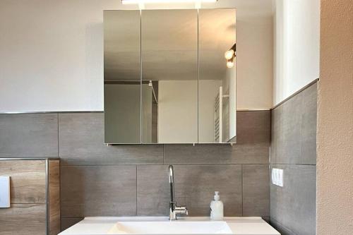 uma casa de banho com um lavatório e um espelho em Großes Ferienhaus in Singhofen 