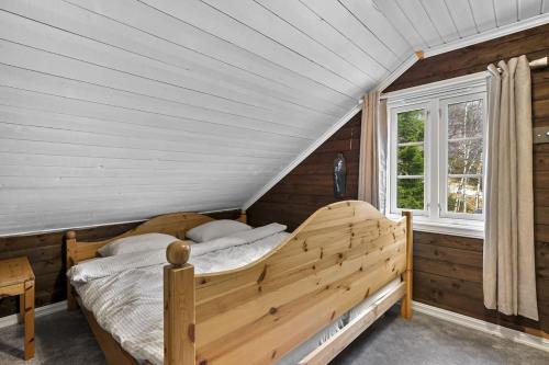 Tjørhom的住宿－Koselig hytte med sjel på fjellet :)，一间卧室设有一张木床和一个窗户。
