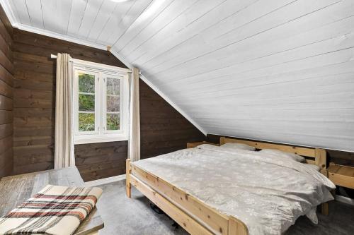 un dormitorio con una cama y una ventana en Koselig hytte med sjel på fjellet :), en Tjørhom