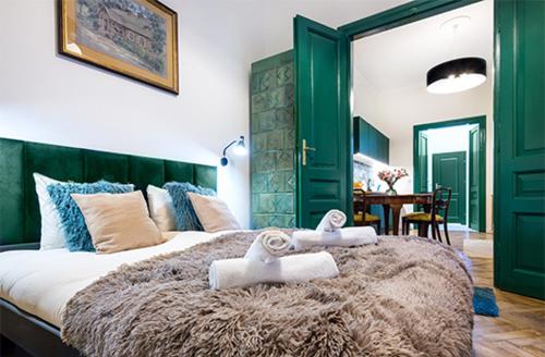 - une chambre avec un grand lit et des serviettes dans l'établissement Tyzenhauz Apartments Lobzowska Street, à Cracovie