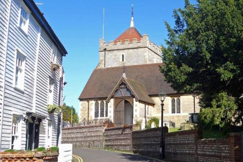 an old church with a steeple on a street at Bexhill Old Town Retreat in Bexhill