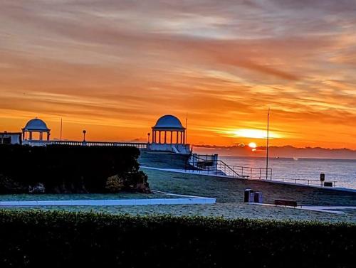 a sunset over a beach with a pier at Bexhill Old Town Retreat in Bexhill