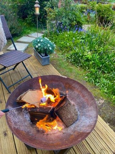 a fire pit on a wooden deck with a table at Bexhill Old Town Retreat in Bexhill
