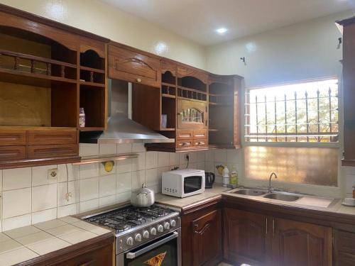 a kitchen with wooden cabinets and a stove top oven at CHEZ CODOU Fann Hock in Dakar