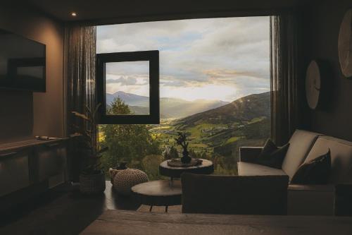 a living room with a large window with a view at Hüttendorf Schlögelberger in Sankt Margarethen im Lungau