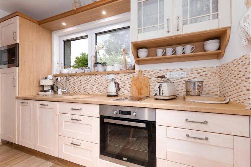 a kitchen with white cabinets and a stove top oven at Vila EVIO Třeboň in Třeboň