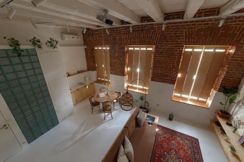 a room with a table and a brick wall at Loft Apartment in Ivano-Frankivsʼk